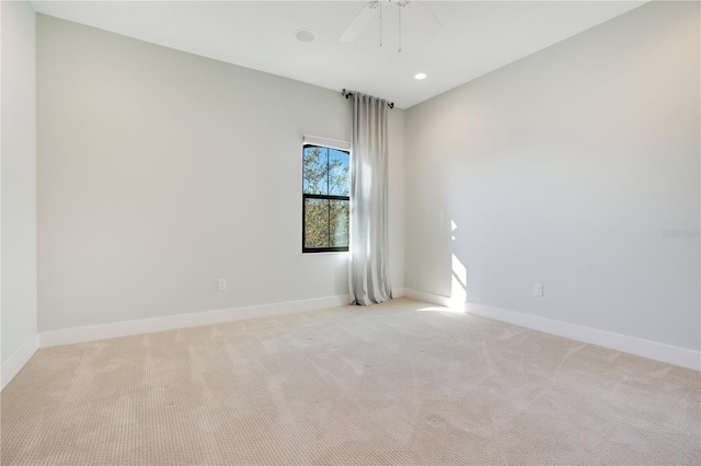 spare room featuring ceiling fan and light colored carpet