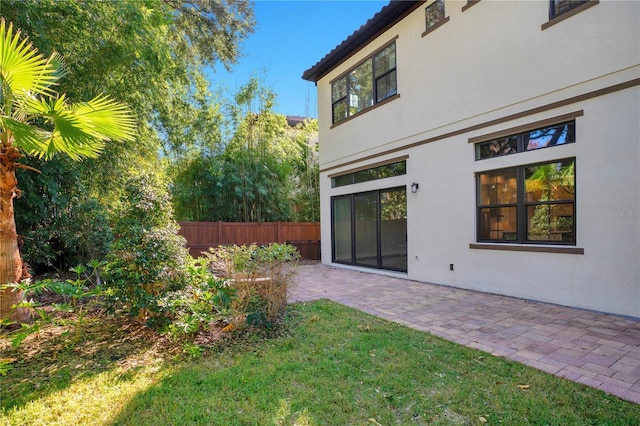 rear view of property with a yard and a patio area