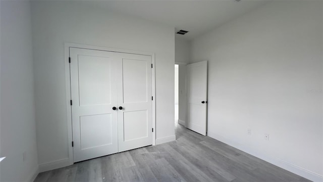 unfurnished bedroom featuring light wood-type flooring and a closet