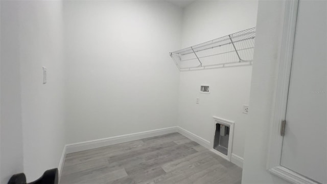 clothes washing area with washer hookup and light hardwood / wood-style flooring