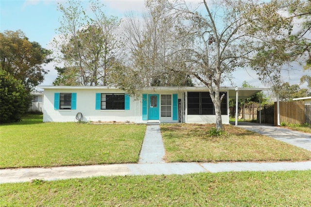 ranch-style house with driveway, a carport, a front yard, and fence