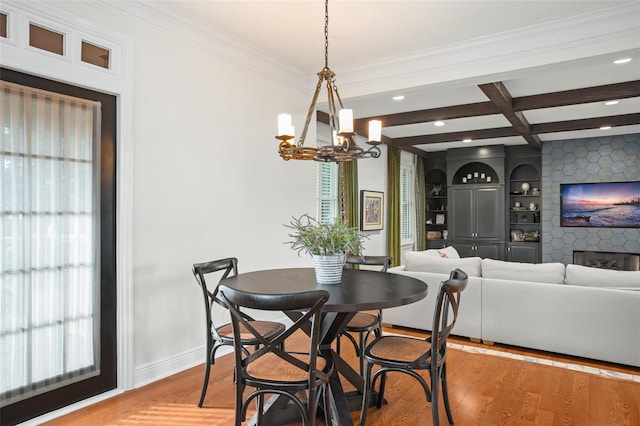 dining room with wood finished floors, baseboards, coffered ceiling, crown molding, and beamed ceiling