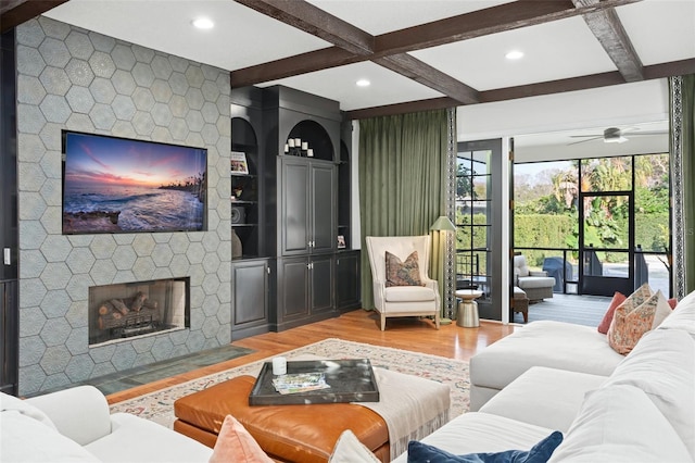 living room featuring beamed ceiling, recessed lighting, a fireplace, and light wood-type flooring