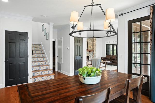 dining room featuring visible vents, wood finished floors, stairway, a fireplace, and crown molding