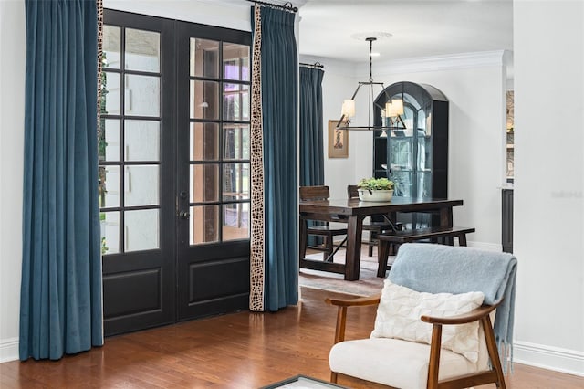 foyer with ornamental molding, wood finished floors, french doors, an inviting chandelier, and baseboards