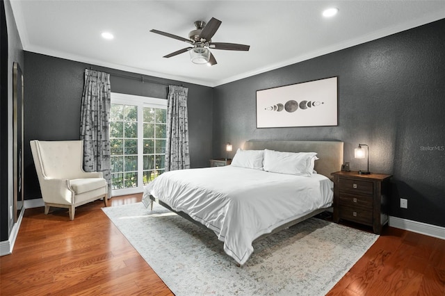 bedroom with crown molding, wood finished floors, baseboards, and a textured wall