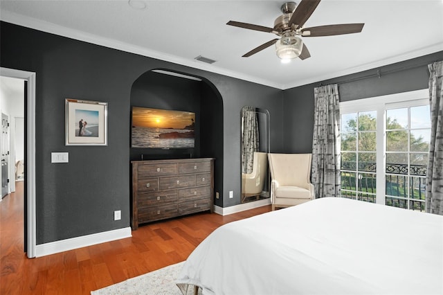 bedroom with visible vents, wood finished floors, crown molding, baseboards, and ceiling fan