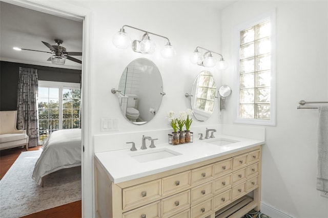 ensuite bathroom featuring a sink, double vanity, ceiling fan, and ensuite bathroom