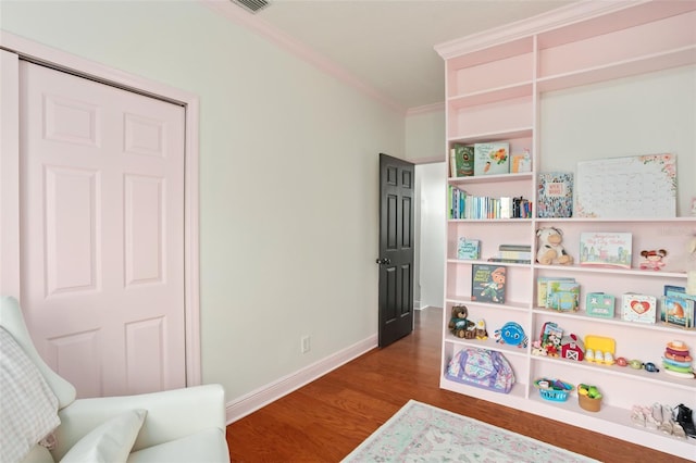 interior space with visible vents, ornamental molding, baseboards, and wood finished floors