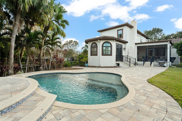 pool featuring a patio, fence, and a sunroom