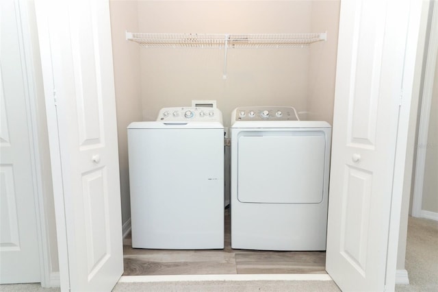 laundry area featuring washing machine and dryer, laundry area, and light wood-style flooring