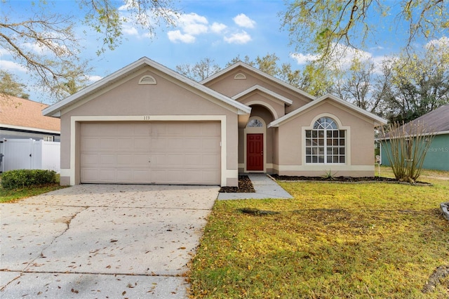 ranch-style house featuring driveway, a garage, fence, and stucco siding