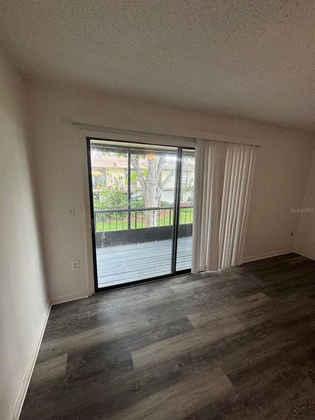 5951 Village Cir Unit Ge, Orlando, FL 32822 - empty room with dark wood-style floors, a textured ceiling, and baseboards