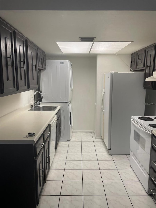 5951 Village Cir Unit Ge, Orlando, FL 32822 - kitchen featuring light tile patterned floors, white appliances, a sink, light countertops, and stacked washing maching and dryer