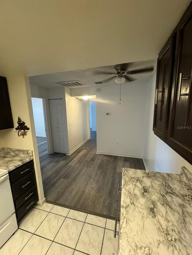 5951 Village Cir Unit Ge, Orlando, FL 32822 - kitchen featuring visible vents, stove, a ceiling fan, dark brown cabinets, and light wood-type flooring