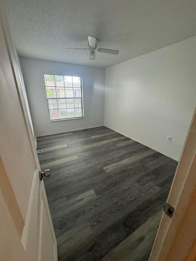 5951 Village Cir Unit Ge, Orlando, FL 32822 - spare room with dark wood-type flooring, a textured ceiling, and a ceiling fan