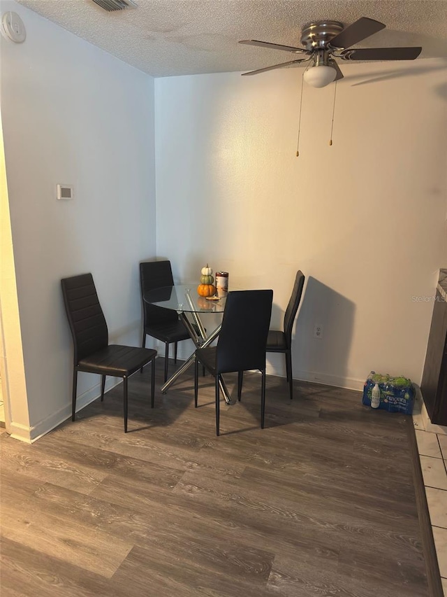 5951 Village Cir Unit Ge, Orlando, FL 32822 - dining room with a textured ceiling, wood finished floors, visible vents, and baseboards