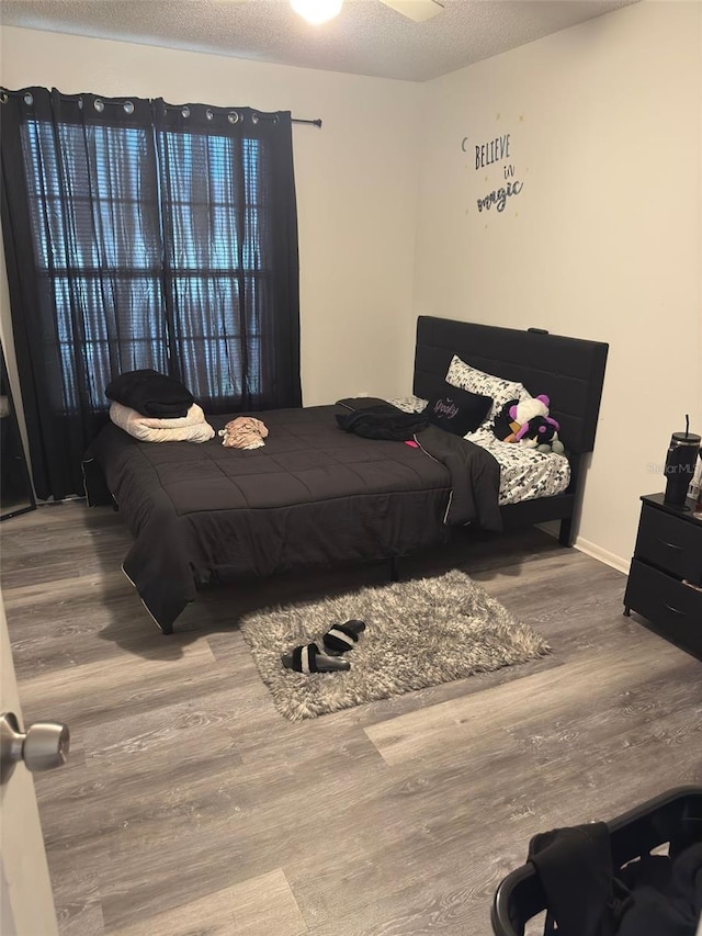 5951 Village Cir Unit Ge, Orlando, FL 32822 - bedroom featuring a textured ceiling, baseboards, and wood finished floors
