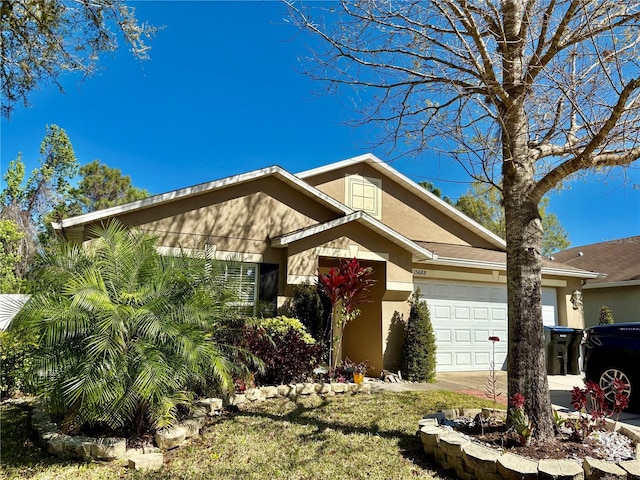 view of front facade featuring a garage, driveway, and stucco siding