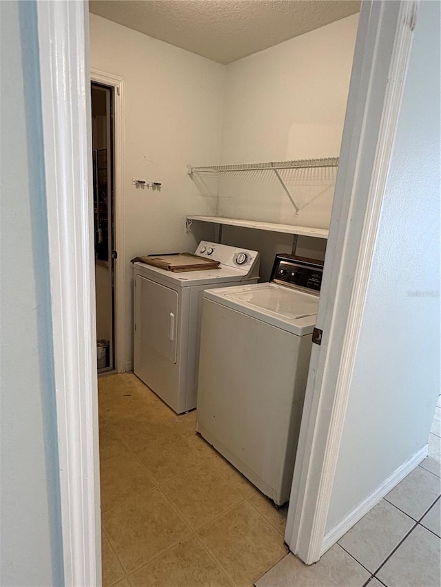 laundry room featuring a textured ceiling, laundry area, and washer and dryer