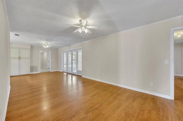 unfurnished living room with ceiling fan, a textured ceiling, light wood-type flooring, and baseboards