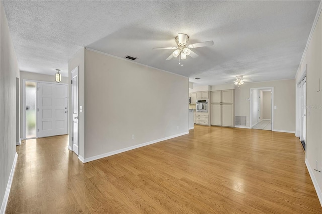 unfurnished living room with a textured ceiling, light wood-type flooring, visible vents, and a ceiling fan