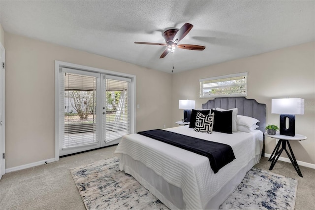 bedroom featuring access to exterior, french doors, light carpet, a textured ceiling, and baseboards