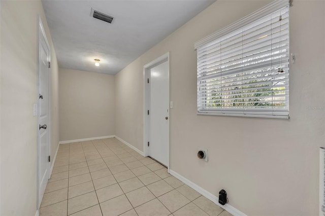 washroom featuring laundry area, baseboards, light tile patterned floors, and visible vents