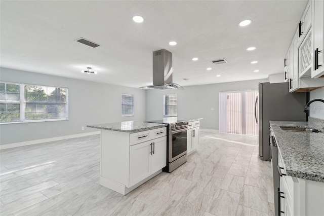 kitchen with light stone countertops, island exhaust hood, stainless steel range with electric stovetop, a kitchen island, and white cabinetry