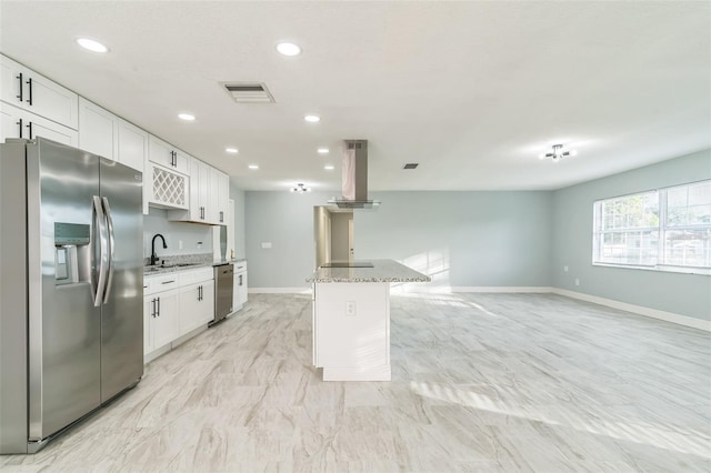 kitchen featuring white cabinets, island range hood, stainless steel appliances, and light stone countertops