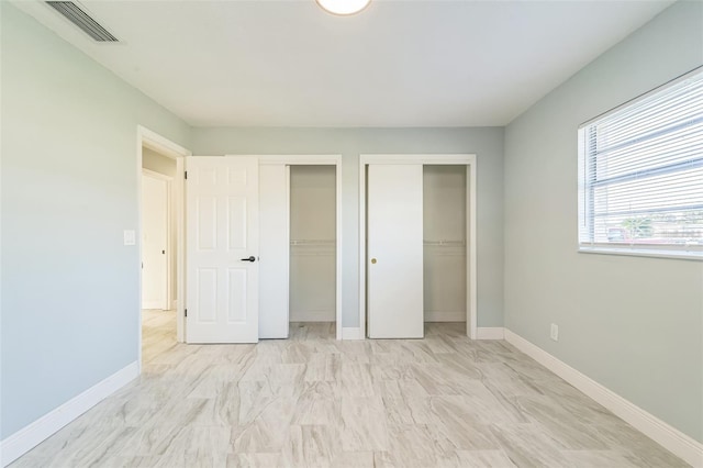 unfurnished bedroom with two closets