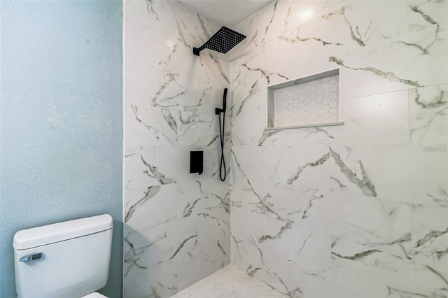 bathroom with tiled shower and toilet