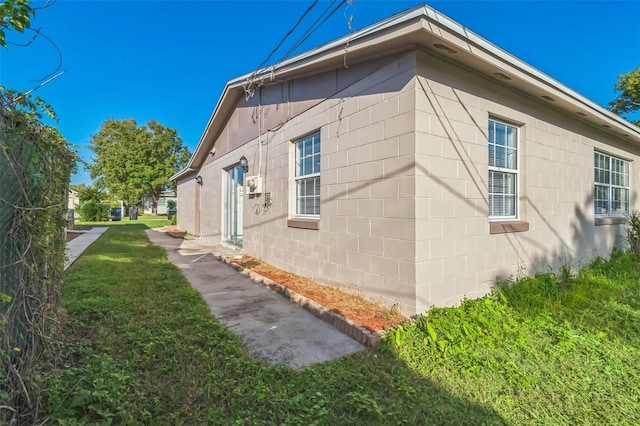 view of side of home with a yard