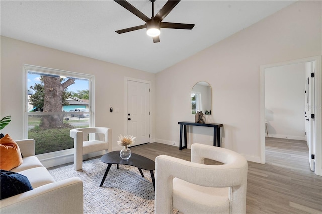 living room with vaulted ceiling, ceiling fan, and light hardwood / wood-style flooring