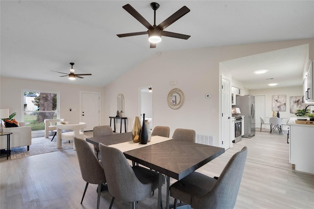 dining room with vaulted ceiling, ceiling fan, and light hardwood / wood-style flooring