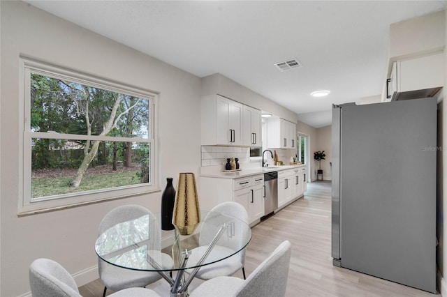 dining space featuring light hardwood / wood-style floors and sink