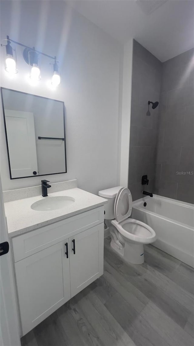 full bathroom featuring toilet, vanity, and tiled shower / bath combo