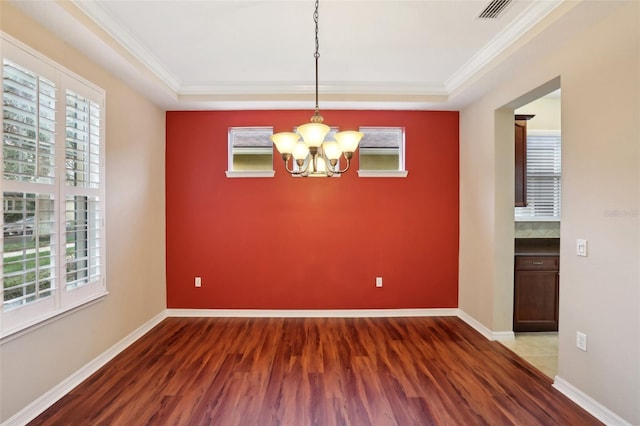 spare room with ornamental molding, visible vents, baseboards, and wood finished floors