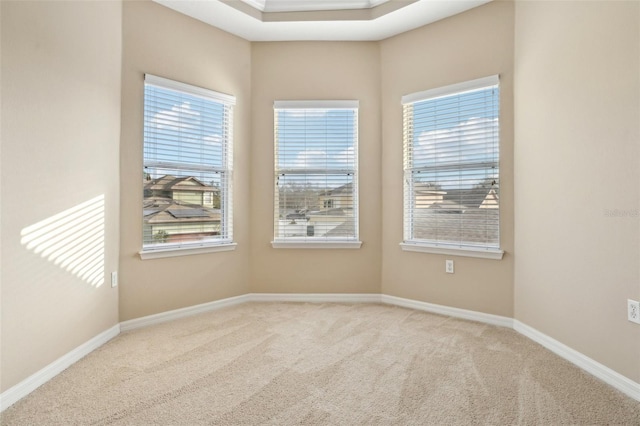 unfurnished room with light colored carpet and baseboards