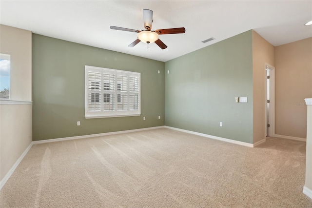 unfurnished room featuring ceiling fan, baseboards, visible vents, and light colored carpet