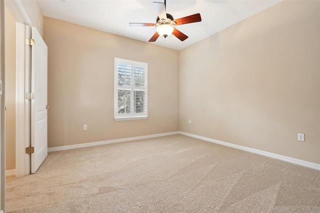 unfurnished bedroom with light carpet, a ceiling fan, and baseboards