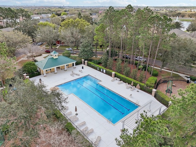 pool with a patio area and fence