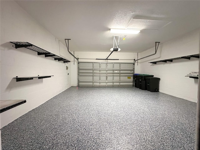 garage with concrete block wall and a garage door opener