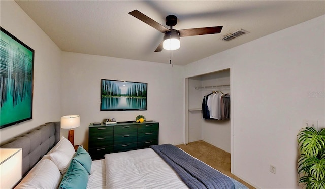 carpeted bedroom with a closet, visible vents, and a ceiling fan