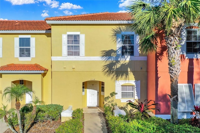 view of front of house with central air condition unit, a tile roof, and stucco siding