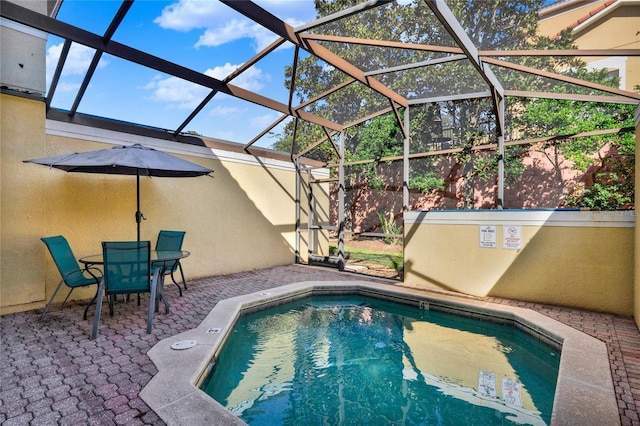 outdoor pool with a lanai and a patio