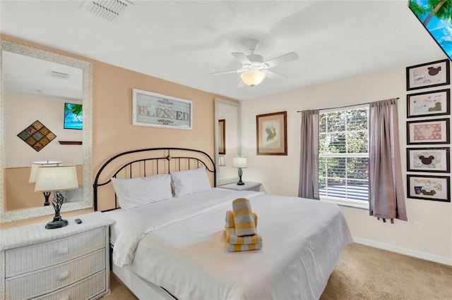 carpeted bedroom featuring a ceiling fan, visible vents, and baseboards