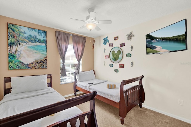 bedroom with ceiling fan, a textured ceiling, carpet, and baseboards