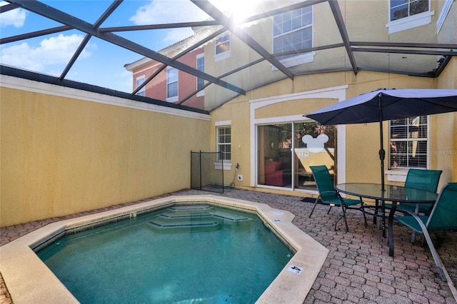 view of swimming pool featuring glass enclosure and a patio area