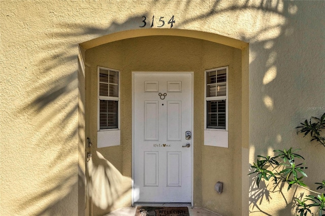 property entrance with stucco siding